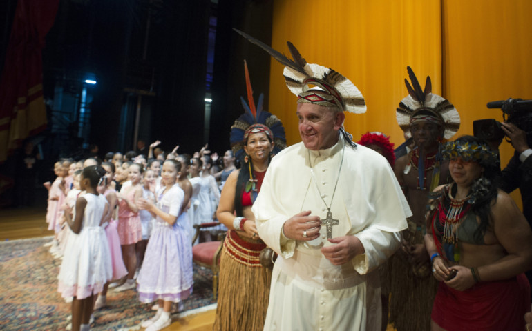 Pope Francis wears an Indian headdress presented to him by members of the Pataxo tribe of Brazil July 27 in Rio de Janeiro. The pope greeted the tribal members as he met with political, economic and cultural leaders at Rio's Municipal Theater. (CNS photo /L'Osservatore Romano)