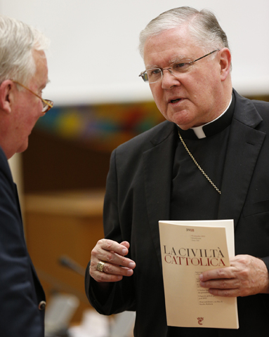 Archbishop Mark Coleridge of Brisbane, Australia, right, holds the Sept. 19 issue of the Italian journal La Civilta Cattolica before a session of the plenary assembly of the Pontifical Council for Social Communications at the Vatican Sept. 20, 2013. (CNS/Paul Haring)