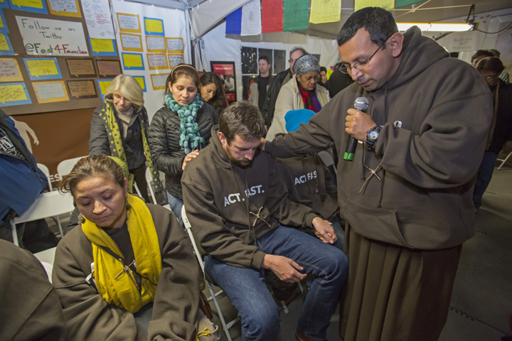 Franciscan Brother Juan Turios of Action Network prays Nov. 30 with immigration reform advocates taking part in "Fast for Families" in a tent on the National Mall near the U.S. Capitol in Washington. (CNS/Jim West)