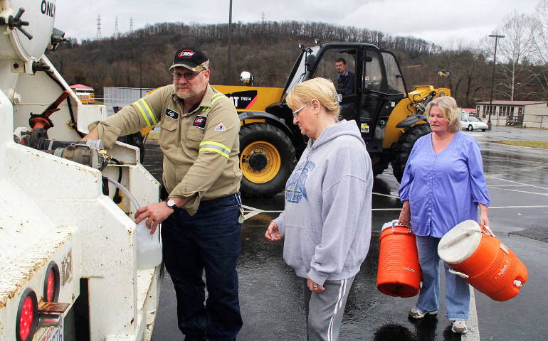 Residents fill up containers with water at an emergency distribution center in Poca, W.Va., Jan.11, after a chemical spill led to a ban on tap water for residents in nine counties. (CNS photo/Lisa Hechesky, Reuters)