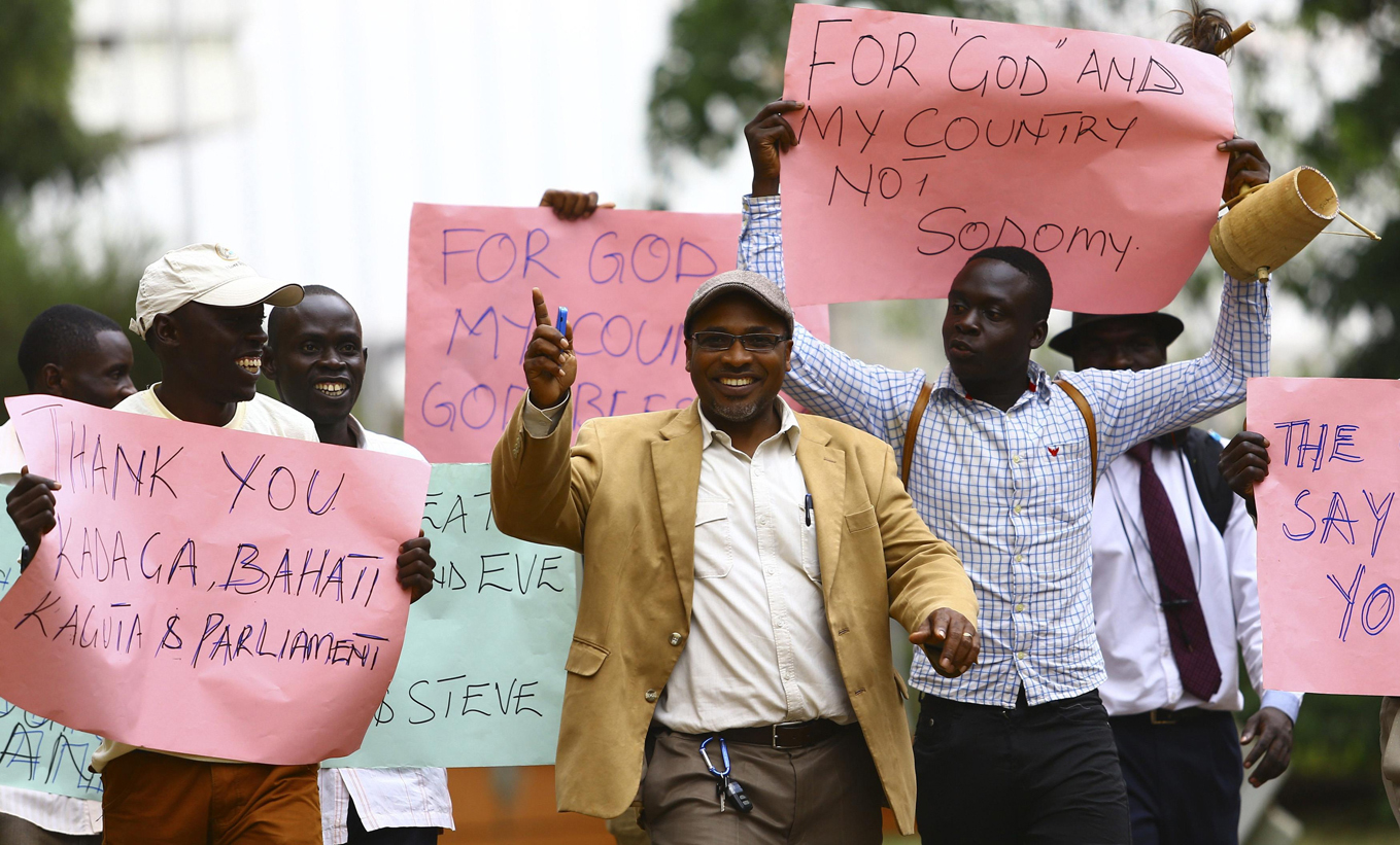 Men carry signs in Kampala, Uganda, Feb. 24, as they celebrate a new anti-homosexuality law. (CNS/Reuters/Edward Echwalu)