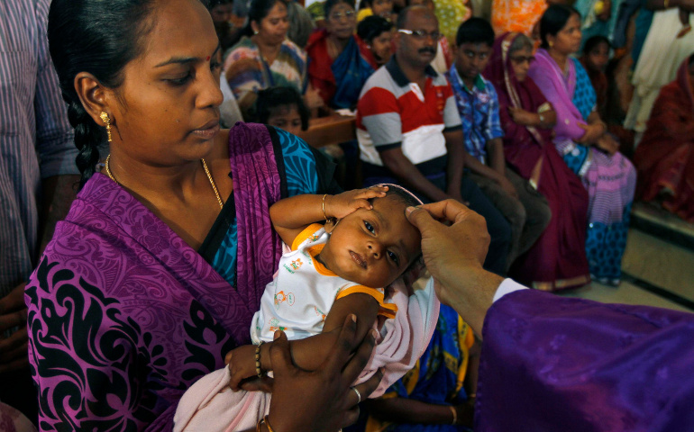 A priest uses ashes to mark a cross on the forehead of a baby during Ash Wednesday Mass at a church in Chennai, India, in 2014. (CNS/Babu, Reuters)  