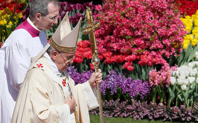 Pope Francis walks past flowers as he leaves after celebrating Easter Mass in St. Peter's Square at the Vatican April 20. (CNS photo/Paul Haring) (April 22, 2014)
