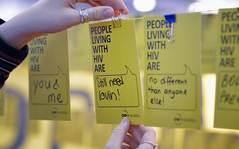 Participants hang cards with messages affirming HIV-positive people in an exhibit July 23, 2014, at the International AIDS Conference in Melbourne, Australia. (CNS/Paul Jeffrey)