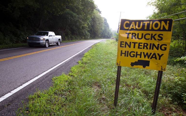 A sign advises drives of a coal truck entrance on West Virginia Route 3 near Naoma, W. Va., Aug. 19. Throughout the mining region of central Appalachia, mountaintop removal mining has flattened more than 500 mountains and led to more than 2,000 miles of steams being filled in, according to The Alliance for Appalachia. (CNS photo/Tyler Orsburn)