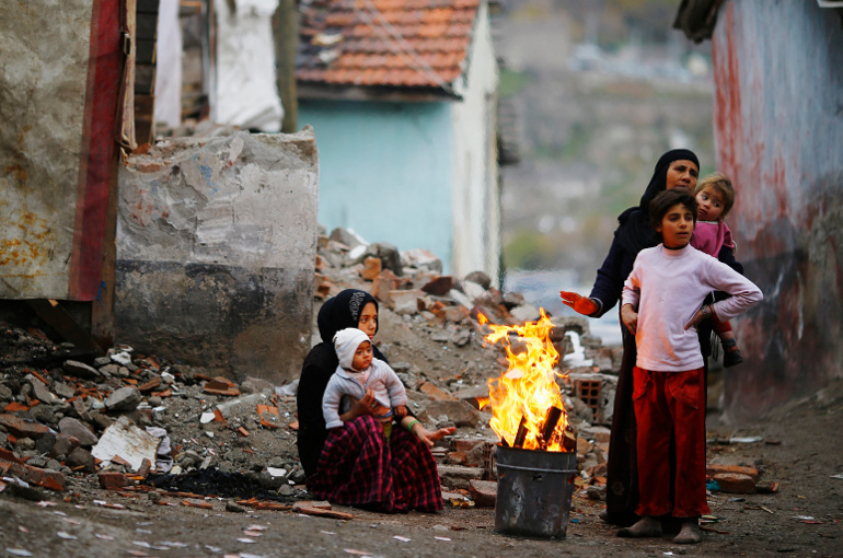 Syrian refugees warm themselves around a fire Dec. 3 in Ankara, Turkey. (CNS/Reuters/Umit Bektas)
