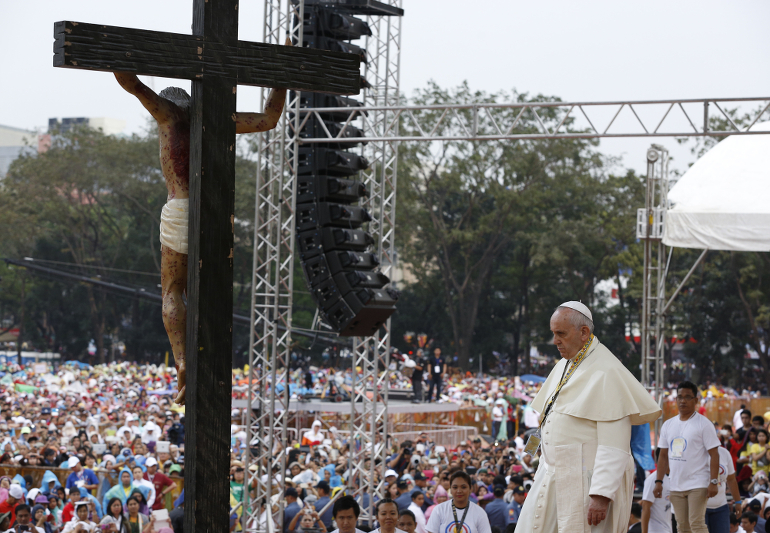 Pope Francis walks forward to reverence a crucifix during a meeting with young people at the University of St. Thomas in Manila, Philippines, Jan. 18. (CNS photo/Paul Haring)