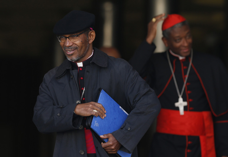 Cape Verdean Cardinal-designate Arlindo Gomes Furtado of Santiago de Cabo Verde leaves a meeting with Pope Francis in the synod hall at the Vatican Feb. 12. Also pictured is Cardinal Chibly Langlois of Les Cayes, Haiti, right. The pope, cardinals and car dinals-designate were meeting for two days to discuss the reform of the Roman Curia in advance of a Feb. 14 consistory. The pope will create 20 new cardinals at the consistory. (CNS photo/Paul Haring)