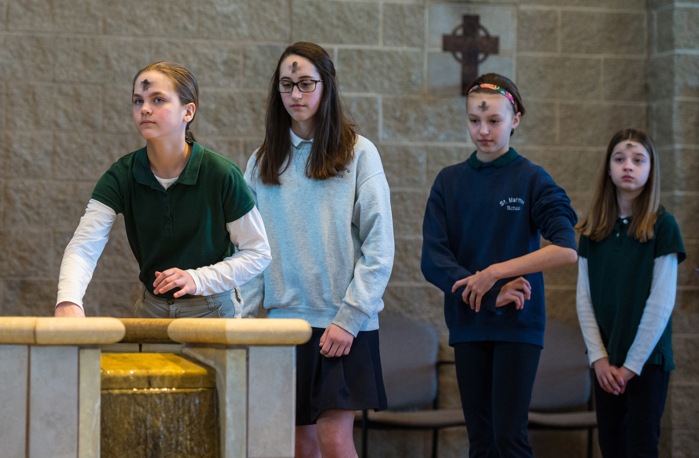 St. Matthew School students take turns to bless themselves with holy water as they exit St. Matthew Church in Allouez, Wis., following a Feb. 18 Ash Wednesday Mass. (CNS/The Compass/Sam Lucero)