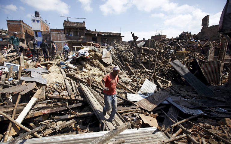A man walks on the rubble of destroyed homes April 27 following an earthquake in Bhaktapur, Nepal. More than 3,600 people were known to have been killed and more than 6,500 others injured after a magnitude-7.8 earthquake hit a mountainous region near Kat hmandu April 25. (CNS photo/Navesh Chitraka, Reuters)