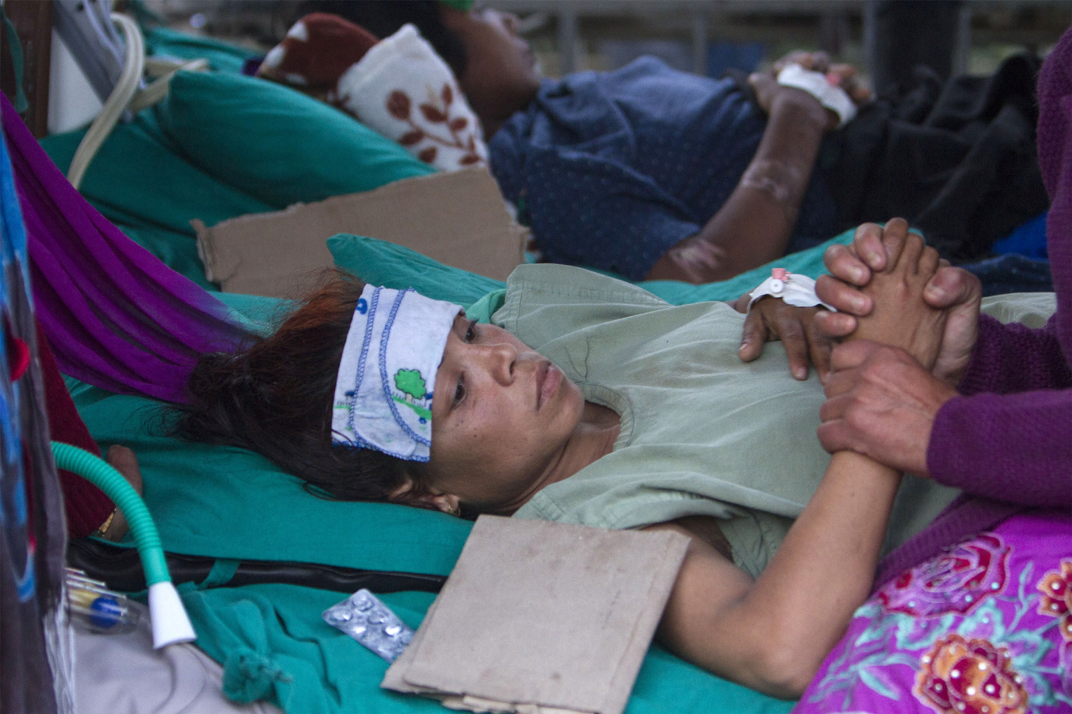 A visitor comforts a young earthquake victim outside a hospital in Kathmandu, Nepal. (CNS/Hemanta Shrestha, EPA)