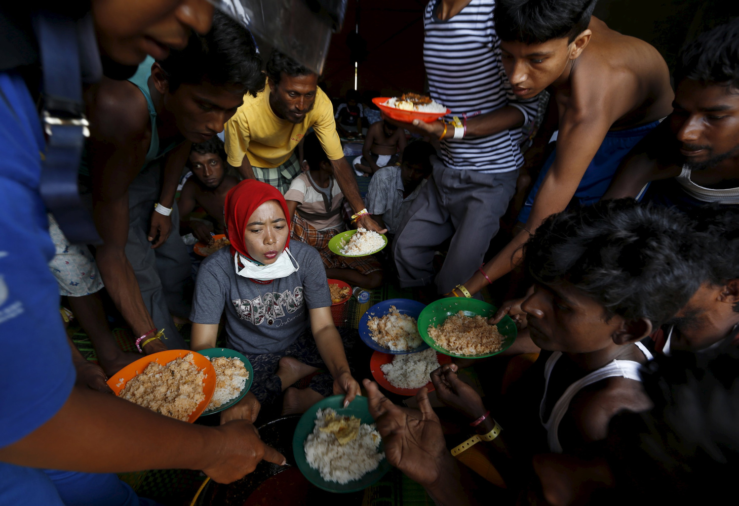 Bangladeshi migrants raise up their plates to ask for more food as breakfast is served by volunteers at a shelter in Kuala Langsa, in Indonesia's Aceh Province, May 19, 2015. Pope Francis said people must stop wasting, start sharing food and other resources. (CNS photo/Beawiharta)
