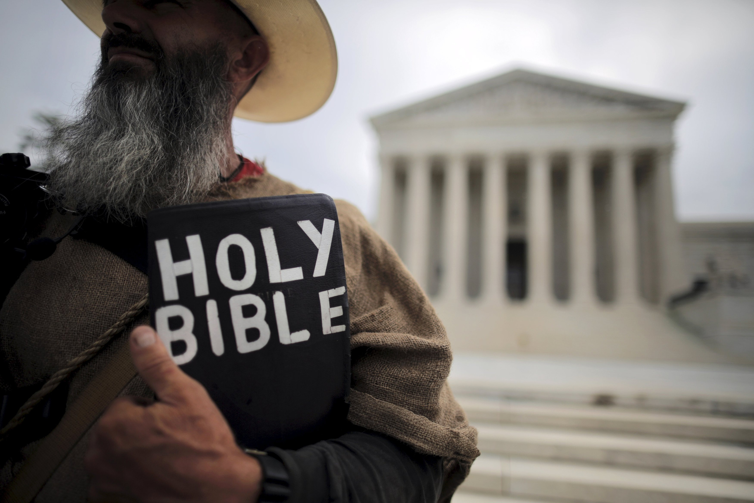 A protester holds a copy of the Bible outside of the U.S. Supreme Court building in Washington June 15. (CNS/Reuters/Carlos Barria) 