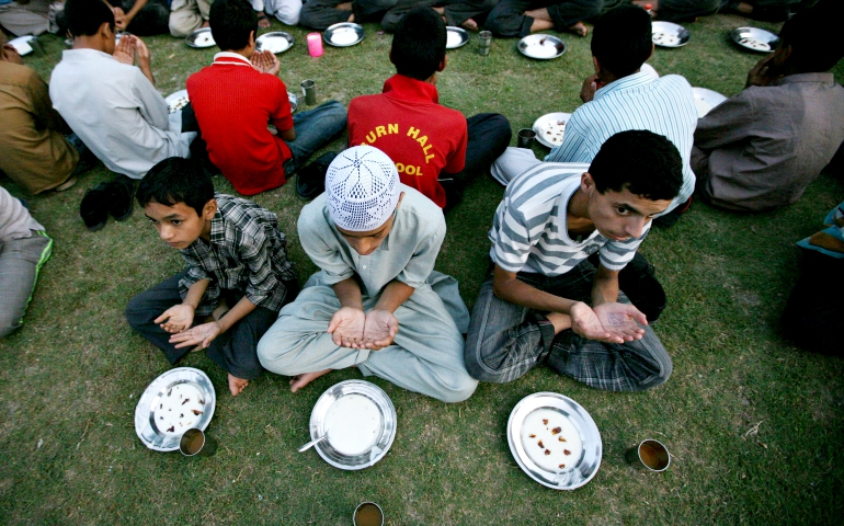 Muslim boys pray as they wait to end their fast of Ramadan in Srinagar, India. (CNS/EPA/Farooq Khan)
