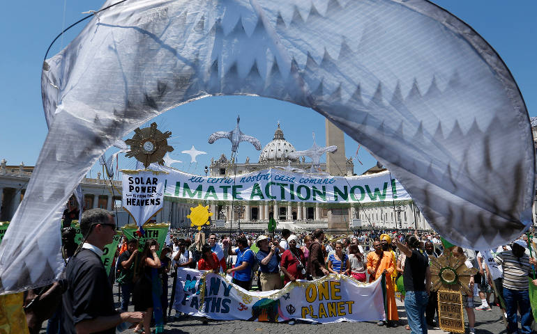 Environmental activists pose for photos after attending Pope Francis' Angelus in St. Peter's Square at the Vatican June 28. Some 1,500 people marched to the Vatican in support of Pope Francis' recent encyclical on the environment. (CNS photo/Paul Haring)