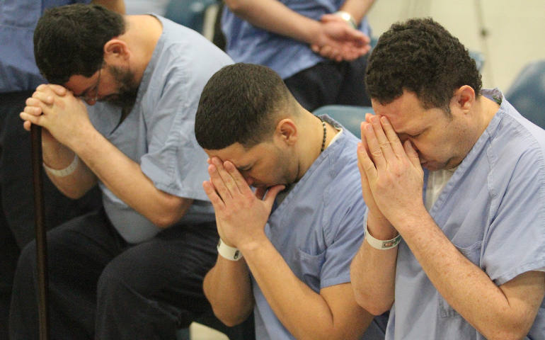 Prison inmates at Curran-Fromhold Correctional Facility in Philadelphia pray during a Mass in mid-January. The prison, which Pope Francis plans to visit Sept. 27 during his two-day visit to the city, currently houses Msgr. William Lynn, a church official convicted of endangering children for his handling of claims of clergy sexual abuse of minors. (CNS photo/Sarah Webb, CatholicPhilly.com)