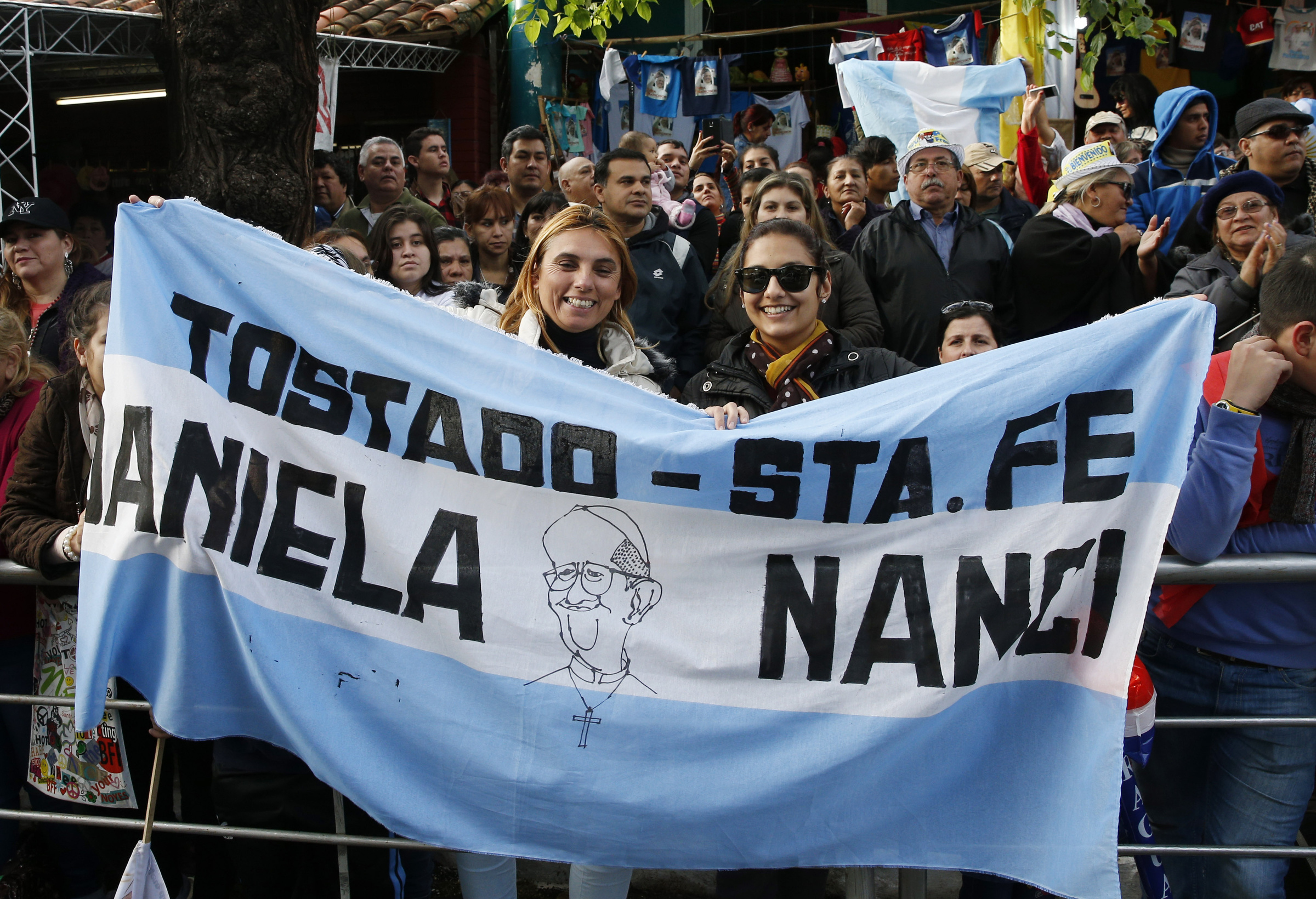 Women hold flag for Pope Francis outside the Caacupe Marian Shrine in Asuncion, Paraguay, July 11. (CNS/Paul Haring)