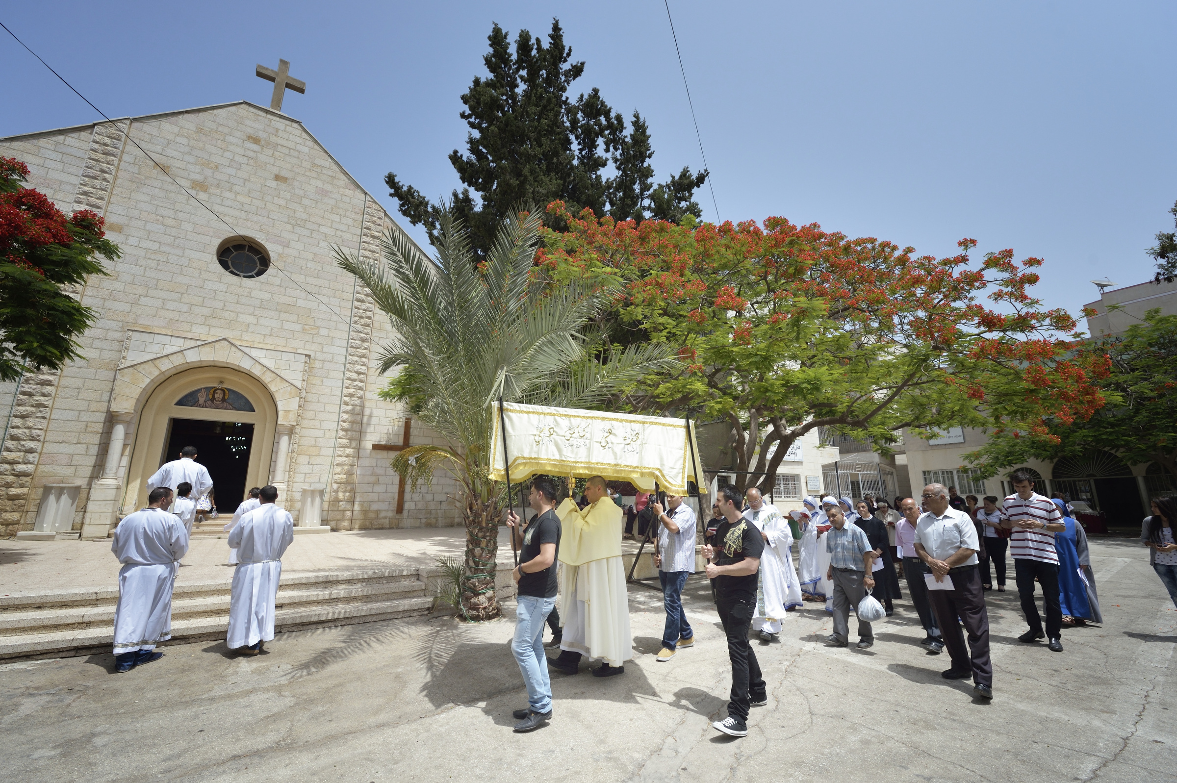Fr. Jorge Hernandez leads a Corpus Christi procession outside Holy Family Catholic Parish in Gaza City, June 7. (CNS/Paul Jeffrey) 