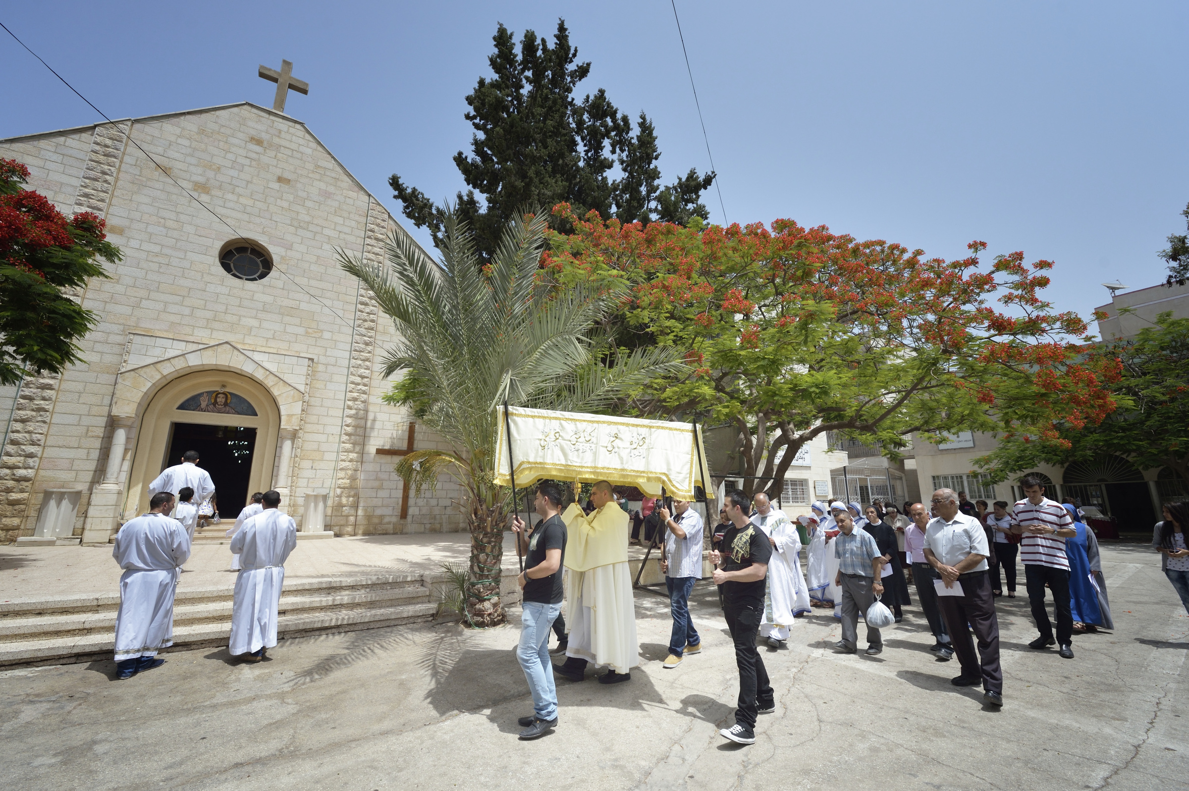 Fr. Jorge Hernandez leads a Corpus Christi procession outside Holy Family Catholic Parish in Gaza City, June 7. (CNS/Paul Jeffrey)