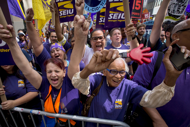 People at a July 22 rally in New York City celebrate passage of a recommendation by the New York State Fast Food Wage Board that the minimum wage for fast-food workers be raised to $15 an hour. It would be raised in increments to $15 by 2018 in the city and by 2021 statewide. (CNS photo/Brendan McDermid, Reuters)