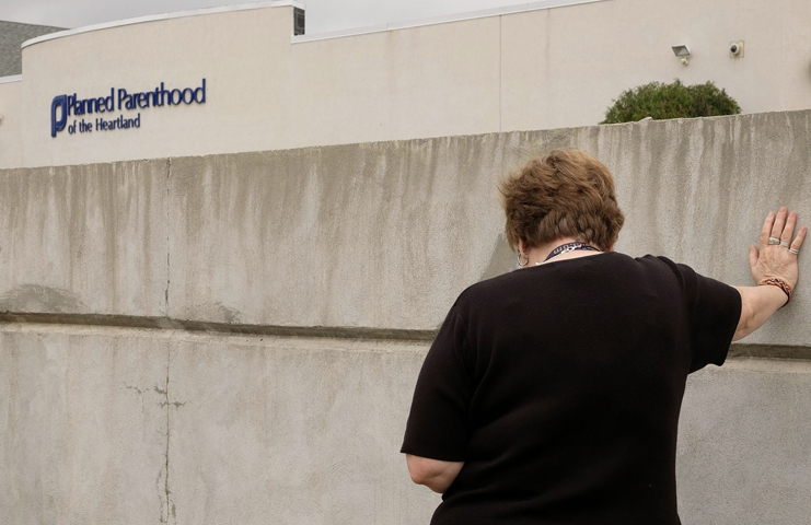 Jane Patnaude of Elk Point, South Dakota, prays at the Planned Parenthood facility in Sioux City, Iowa, after attending a "Women Betrayed" rally in Sioux City July 28. (CNS/Jerry L. Mennenga, The Catholic Globe) 
