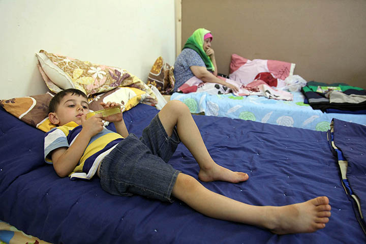 An Iraqi Christian child who fled from violence in Mosul, Iraq, lies on a bed in 2014 at a church in Amman, Jordan. The world continues to be silent in the face of widespread persecution of Christians and other religious minorities, Pope Francis said. (CNS photo/Jamal Nasrallah, EPA) 