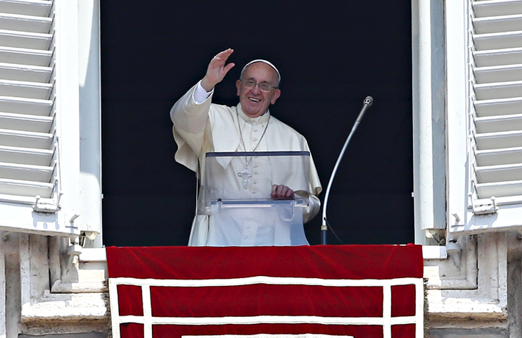 Pope Francis waves as he leads the Angelus from the window of his studio overlooking St. Peter's Square at the Vatican Aug. 9. (CNS photo/Tony Gentile, Reuters) 
