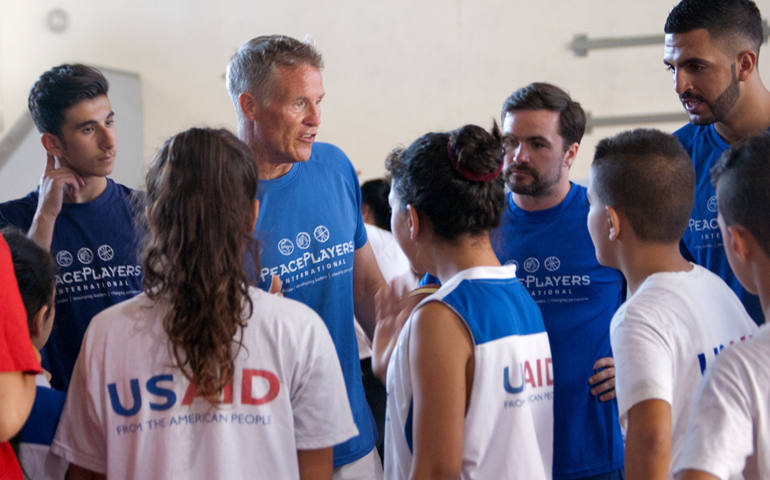 Philadelphia 76ers Coach Brett Brown gives pointers to Arab and Israeli youth during a July 30 basketball clinic sponsored by PeacePlayers International in Jerusalem. (CNS photo/Mary Knight)