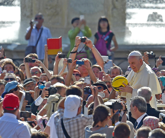Pope Francis holds a sports ball that was given to him as he arrives for his weekly audience in St. Peter's Square at the Vatican Aug. 26. (CNS/Ettore Ferrari, EPA)