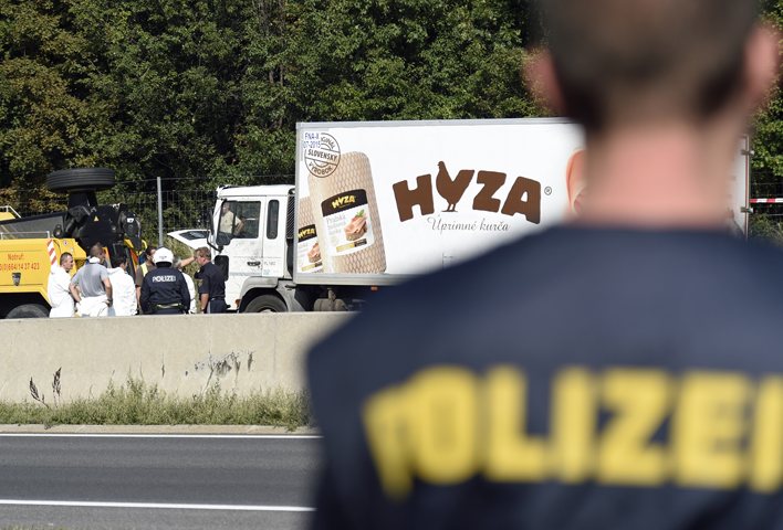 Forensic experts investigate a truck in which refugees were found dead on a freeway between Parndorf and Neusiedl, Austria, Aug. 27. (CNS/Herbert P. Oczeret)