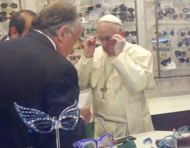 Pope Francis tries on a pair of glasses in an optical store in downtown Rome Sept. 3. Romans and tourists crowded outside the shop to catch a glimpse of the pope inside as he had his eyes measured for a new set of bifocal lenses. (CNS/Chiara Apollonj, Reuters)