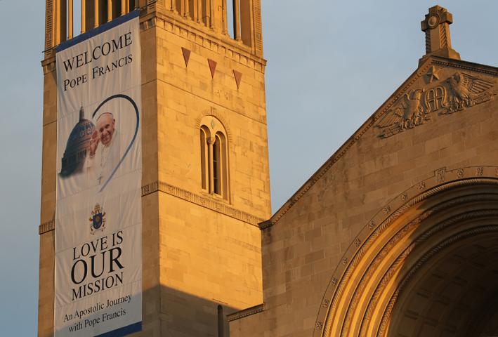 An image of Pope Francis hangs from the bell tower of the Basilica of the National Shrine of the Immaculate Conception in Washington Sept. 20. Pope Francis will celebrate Mass outside the basilica Sept. 23. (CNS/Bob Roller)