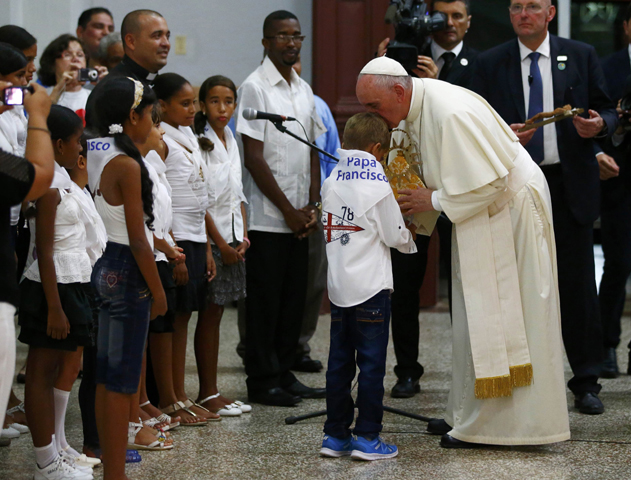 Pope Francis receives a gift from children at the shrine devoted to Our Lady of Charity in El Cobre, Cuba, Sept. 21. (CNS/Tony Gentile, Reuters)