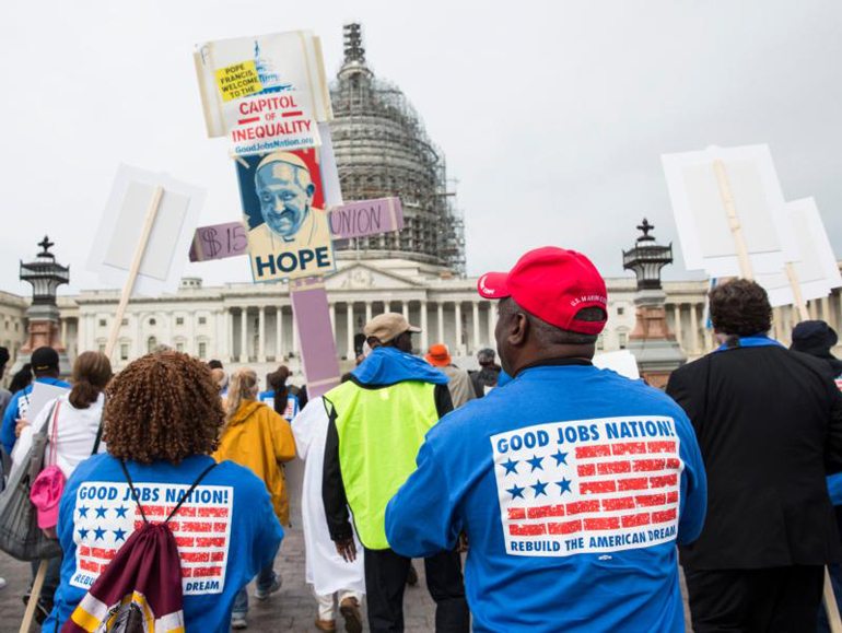 Contract workers from the U.S. Capitol and other federal buildings rally during a strike over wages in Washington Sept. 22. The group invoked the name of Pope Francis as they demonstrated for higher pay ahead of the pontiff's arrival in the nation's capital. (CNS photo/Joshua Roberts)