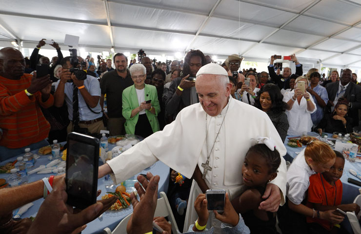 A girl hugs Pope Francis as he visits with people at St. Maria's Meals Program of Catholic Charities in Washington Sept. 24. (CNS photo/Paul Haring)