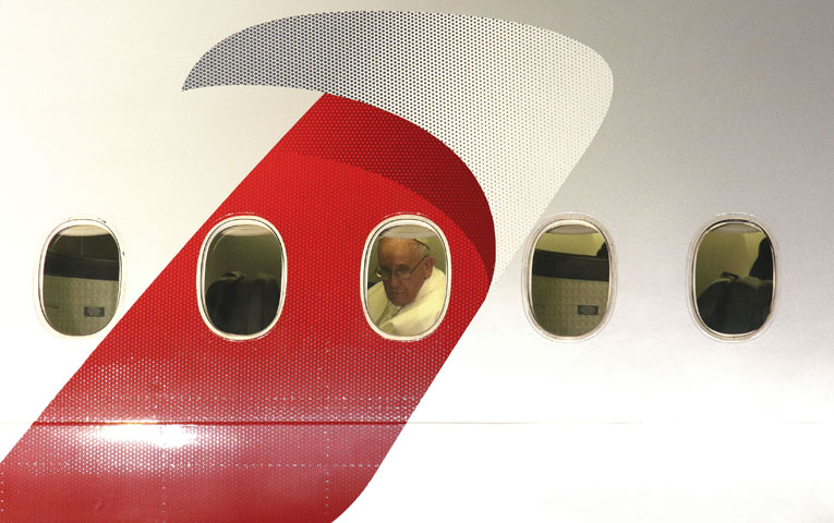 Pope Francis looks out a window after boarding an American Airlines jetliner at Philadelphia International Airport Sept. 27 for his return to Rome following a six-day apostolic visit to the U.S. (CNS/Gregory A. Shemitz)