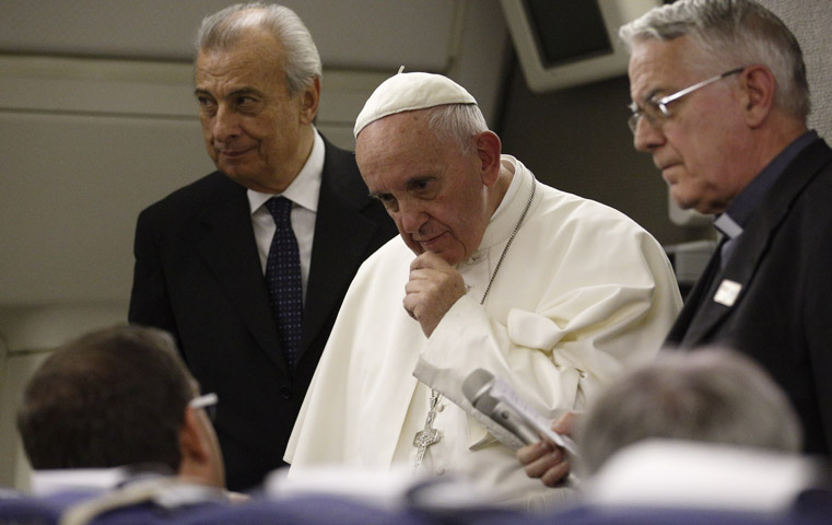 Pope Francis listens as he takes questions from journalists aboard his flight from Philadelphia to Rome Sept. 27. (CNS photo/Paul Haring)