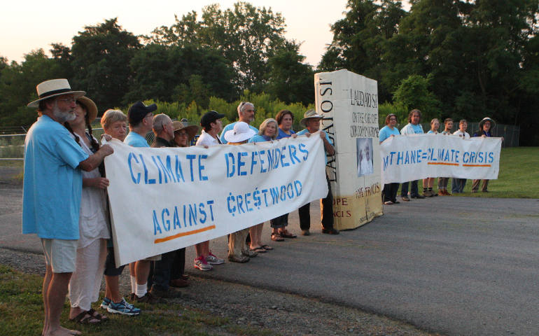 A line of protesters Aug. 18 blocks the main gate at the Crestwood Midstream Partners gas storage facility on the shores of Seneca Lake in Reading, N.Y., near Watkins Glen, N.Y. Eighteen people were arrested while reading Pope Francis' encyclical "Laudato Si'." (CNS photo/Dennis Sadowski)