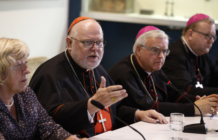 Cardinal Reinhard Marx of Munich-Freising, president of the German bishops' conference, and other German bishops and a lay synod observer, hold a press conference at the Vatican after the opening session of the Synod of Bishops on the family at the Vatican Oct. 6. (CNS/Paul Haring)