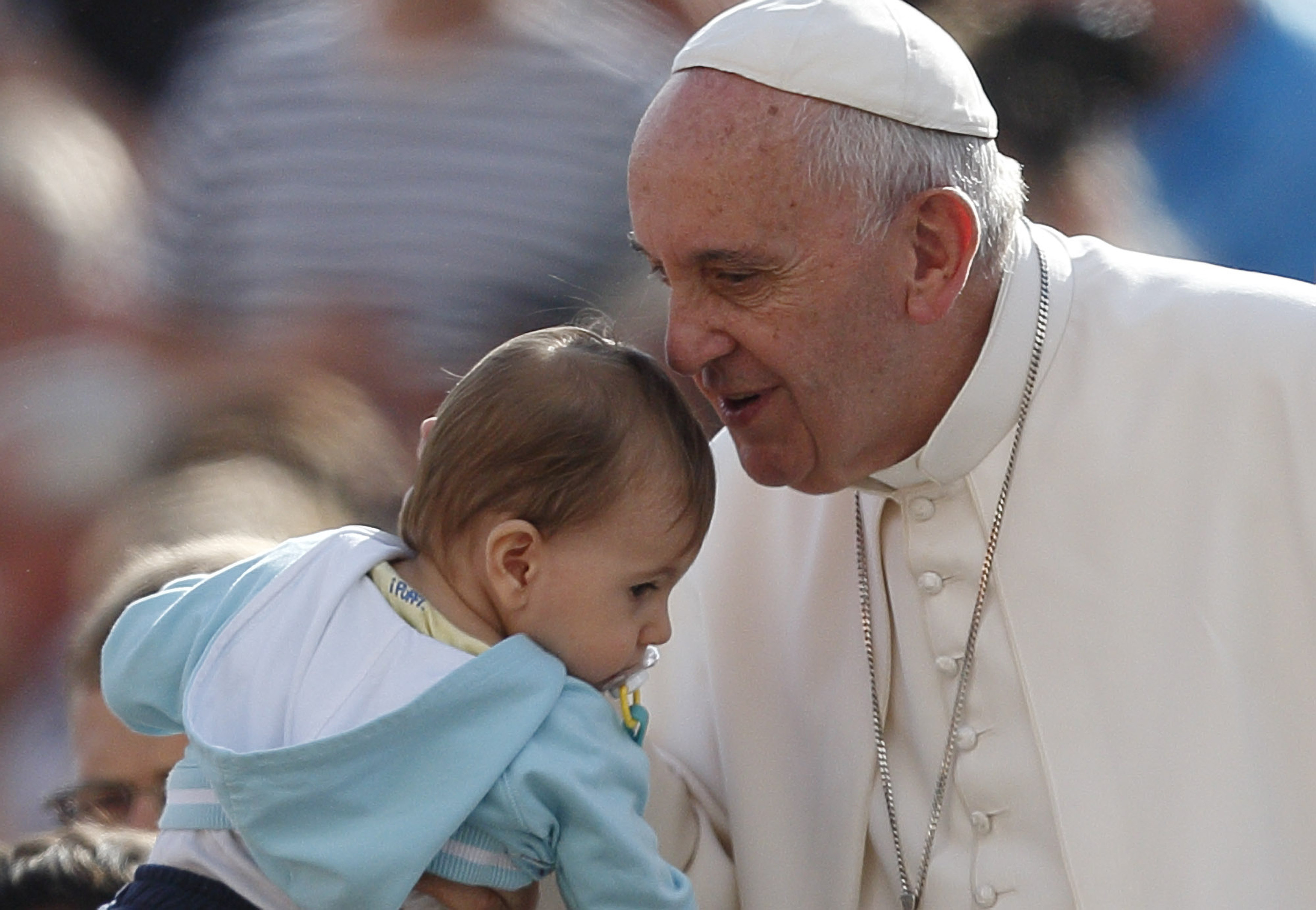 Pope Francis greets a baby during his general audience in St. Peter's Square at the Vatican Oct. 7. The pope said that when families mirror God's love for all, they teach the church how it should relate to all people. (CNS/Paul Haring) 