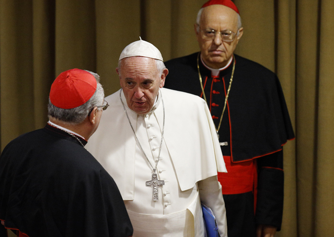 Pope Francis speaks with a cardinal as he arrives for a session of the Synod of Bishops on the family at the Vatican Oct. 15. At right is Cardinal Lorenzo Baldisseri, general secretary of the Synod of Bishops. (CNS/Paul Haring)
