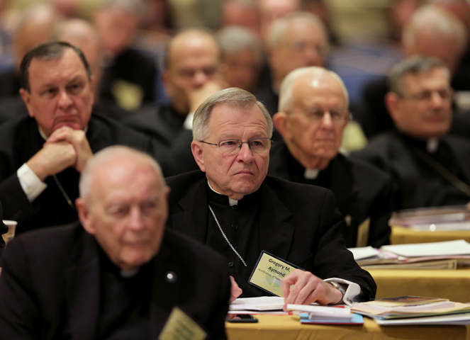 Archbishop Gregory M. Aymond of New Orleans, center, and other prelates listens to a speaker during the 2014 annual fall general assembly of the U.S. Conference of Catholic Bishops in Baltimore. At this year's Nov. 16-19 assembly, the bishops, among other things, will address USCCB priorities and a statement on political responsibility. (CNS/Bob Roller) 