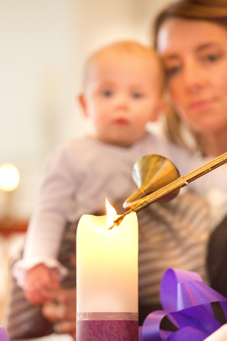 Amy Olsen, her 1-year-old daughter, Piper, lights a candle on the Advent wreath at St. Raphael the Archangel Church in St. Louis Oct. 29. (CNS/Lisa Johnston)