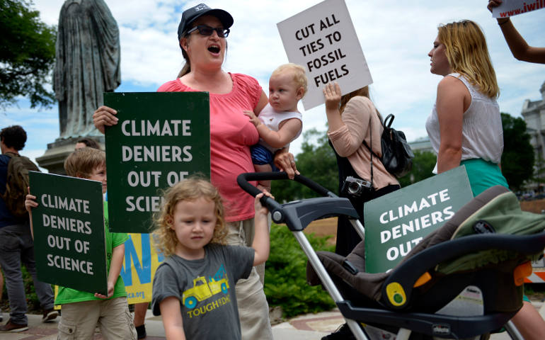 Protesters chant and display signs during a mid-June 2105 climate change rally in Washington. (CNS photo/Shawn Thew, EPA)