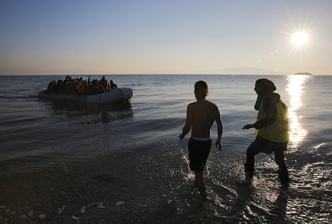 Volunteers approach a raft overcrowded with migrants and refugees on the Greek island of Lesbos Nov. 17. (CNS photo/Yannis Behrakis, Reuters) 