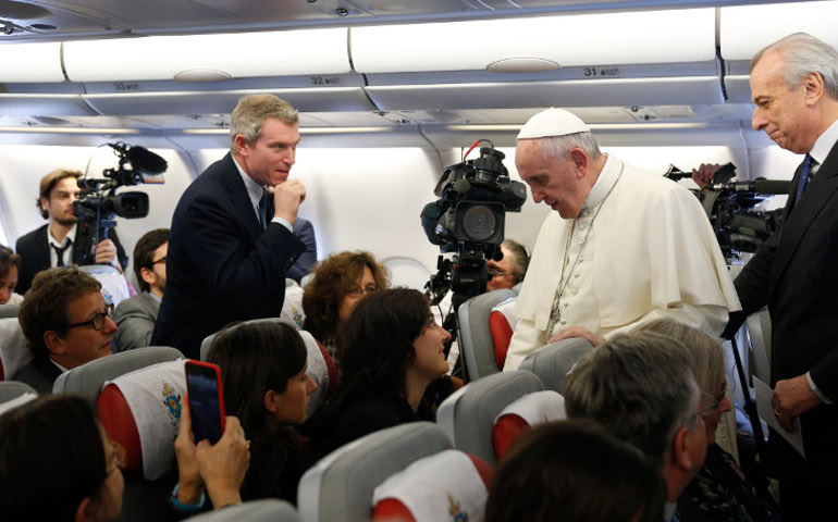 Pope Francis greets journalists aboard his flight from Rome to Nairobi, Kenya, Nov. 25. (CNS/Paul Haring)