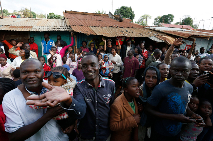 A crowd waiting to see Pope Francis waves to journalists during the pope's visit to a Catholic parish in the Kangemi slum on the outskirts of Nairobi, Kenya, Nov. 27. (CNS photo/Paul Haring)