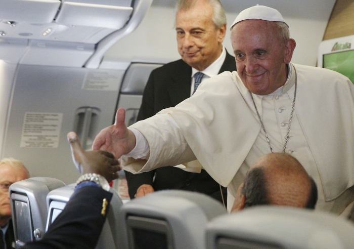 Pope Francis greets a journalist aboard his flight from Bangui, Central African Republic, to Rome Nov. 30. The pope answered questions from journalists for about an hour. (CNS photo/Paul Haring)