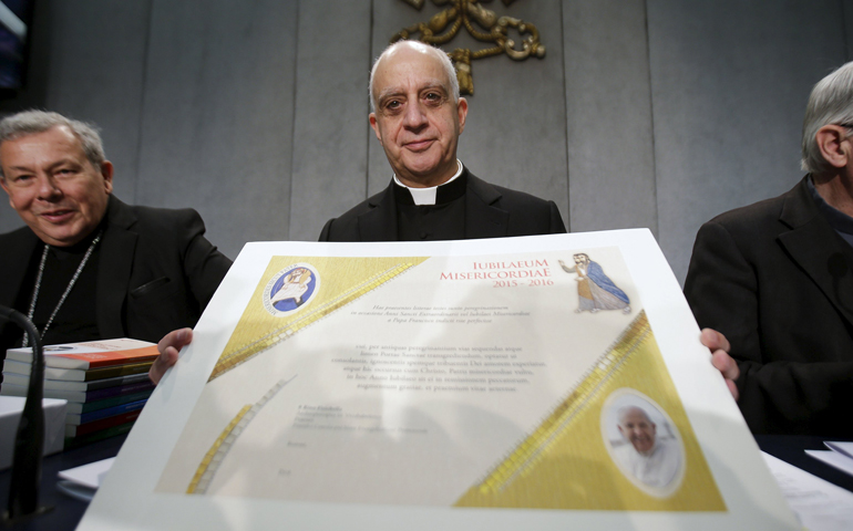 Archbishop Rino Fisichella shows reporters Dec. 4 the certificate that will be given to the pilgrims who will arrive at the Vatican by foot during the Year of Mercy.
