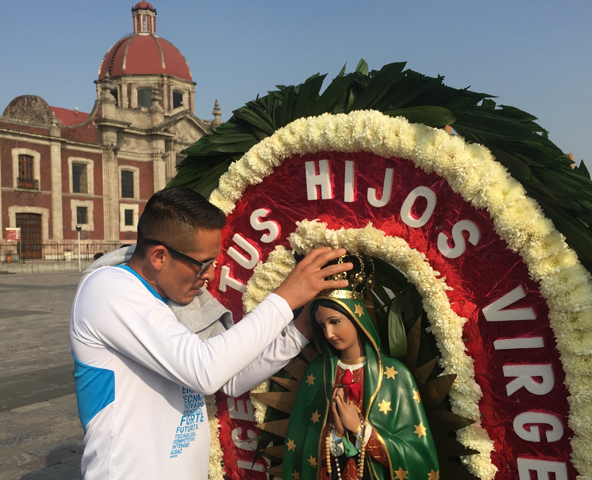 A man adjusts the crown on a statue of Our Lady of Guadalupe Dec. 6 in Mexico City.(CNS/David Agren)